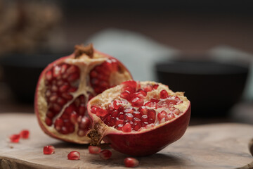 Ripe small pomegrenate on olive wood board