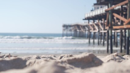 Below wooden Crystal pier on piles, ocean beach water waves, California USA. Summer vacations on Mission beach, San Diego shore. Under waterfront promenade on sea coast. Seamless looped cinemagraph. © Dogora Sun