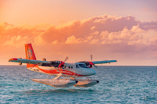 02.02.22, Ari atoll, Maldives: Exotic scene with seaplane on Maldives sea landing. Seaplane over sunset sea before landing. Amazing sunset sky clouds, luxury travel, vacation transportation concept