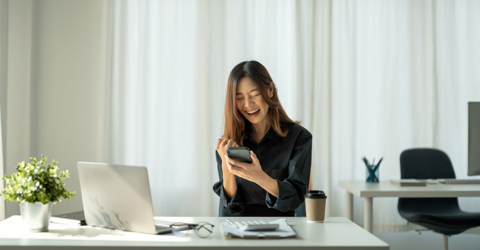 Portrait of happy young business asian woman celebrating success with arms up. positive expression, sucess in business concept