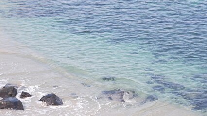 Naklejka premium Crystal blue azure transparent ocean, La Jolla cove, California coast, USA. Turquoise translucent clear sea waves from above. Rippled water surface, tropical beach paradise lagoon, summer vacations.