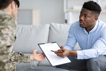 Black man psychologist giving military man recommendations, showing list