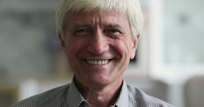 Close up portrait handsome face elderly man with candid wide toothy smile look at camera. Aged healthy optimistic male, comfort retired life, dental clinic service ad for older citizen people concept
