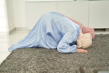 Muslim women bowing down and praying at home