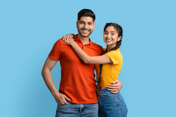 Fototapeta premium Portrait of positive young arabic couple hugging and posing at camera