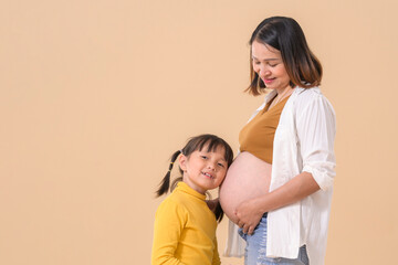 Fototapeta premium Girl listening baby's heartbeat hugging pregnant mother's belly