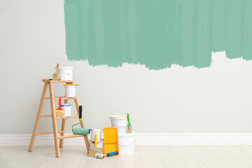 Decorator's kit of tools and paints near wall indoors © New Africa