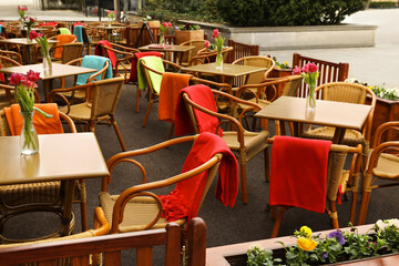 Outdoor cafe with wicker chairs and wooden tables