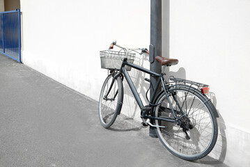 Fototapeta na wymiar Vintage bicycle with basket locked to street post outdoors