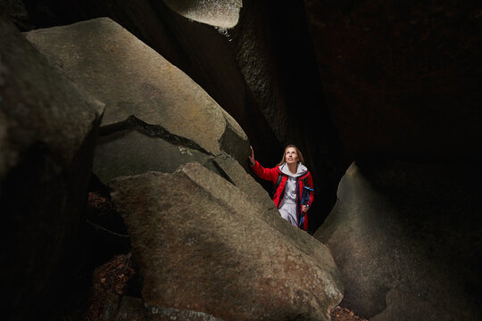 Female Looking At Light Coming Through Hole In Empty Cave