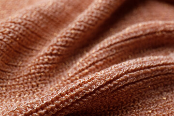 Brown knitted fabric as background, closeup view