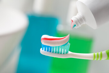 Fototapeta na wymiar Applying toothpaste on brush against blurred background, closeup