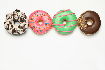 Different delicious glazed doughnuts on white background, top view