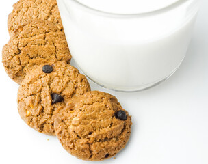 Chocolate chip cookies with glass of milk on wood plate and isolated white background. 
