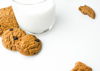 Chocolate chip cookies with glass of milk on wood plate and isolated white background. 