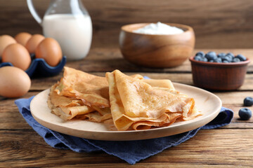 Delicious crepes served on wooden table. Space for text