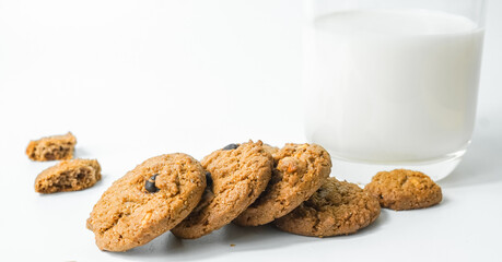 Chocolate chip cookies with glass of milk on wood plate and isolated white background. 