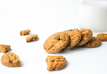 Chocolate chip cookies with glass of milk on wood plate and isolated white background. 