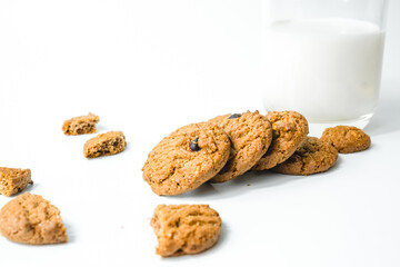 Chocolate chip cookies with glass of milk on wood plate and isolated white background. 