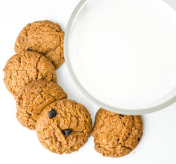 Chocolate chip cookies with glass of milk on wood plate and isolated white background. 