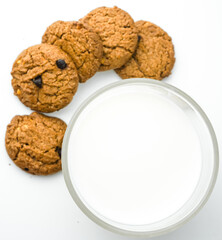 Chocolate chip cookies with glass of milk on wood plate and isolated white background. 