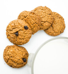 Chocolate chip cookies with glass of milk on wood plate and isolated white background. 