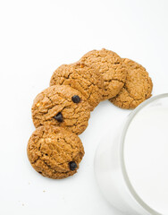 Chocolate chip cookies with glass of milk on wood plate and isolated white background. 