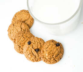 Chocolate chip cookies with glass of milk on wood plate and isolated white background. 