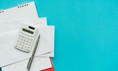 close up top view on calculator and open over group of invoice letter mail from bank on blue...