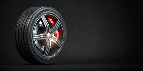 Car wheel. Disk with tyre and brakes on black background. - obrazy, fototapety, plakaty