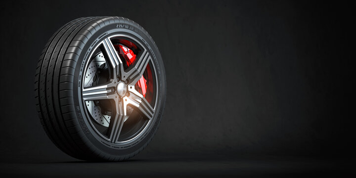 Car wheel. Disk with tyre and brakes on black background.