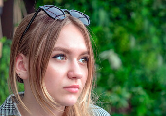 portrait of a beautiful young European girl, 16-17 years old, with long brown hair with a pensive look