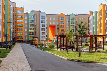 Bright urban landscape of a new residential area with modern multi-apartment colored houses and a...