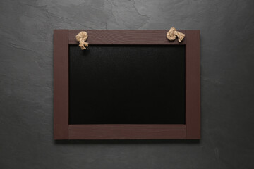 Obraz premium Clean small black chalkboard on dark table, top view