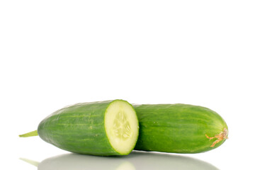 One whole and one half of a juicy smooth cucumber, macro, isolated on a white background.