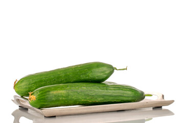 Two juicy smooth cucumbers on a metal tray, macro isolated on a white background.