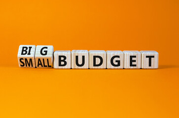 Big or small budget symbol. Turned wooden cubes and changed concept words Small budget to Big budget. Beautiful orange table orange background, copy space. Business big or small budget concept.