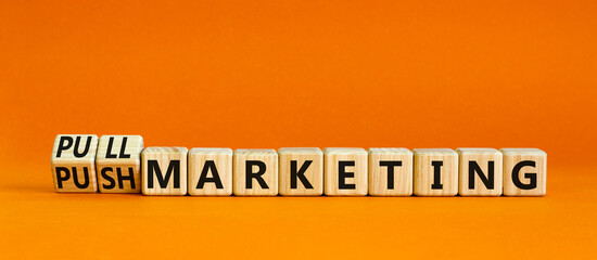 Pull or push marketing symbol. Turned wooden cubes and changed concept words Pull marketing to Push marketing. Beautiful orange background. Business and pull or push marketing concept. Copy space.