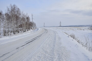 Fototapeta na wymiar Snow covered dirt road in winter, Russia