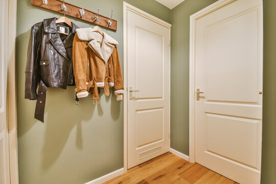 Trendy jackets hanging in corridor of modern apartment