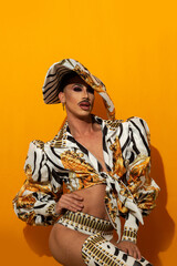 Portrait of drag queen modeling with mustache yellow background
