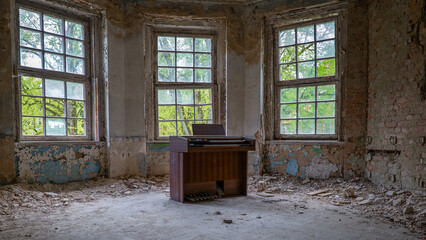 10.05.2022 - Oranienburg, Germany:  Old dusty piano synthesizer in a room with destroyed walls....