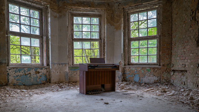 10.05.2022 - Oranienburg, Germany:  Old dusty piano synthesizer in a room with destroyed walls. Abandoned German-Soviet lung hospital. Ruined tuberculosis-Sanatorium "Heilstätte Grabowsee"