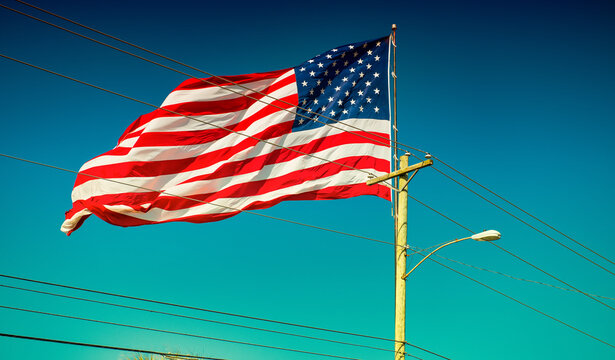 Giant American Flag With Blue Sky On The Background.