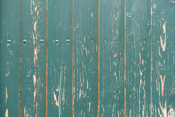 Turquoise painted timber planks background. Vertical mounted wooden boards as a building exterior. Architectural backdrop with a natural texture. Weathered row of lumber panels.