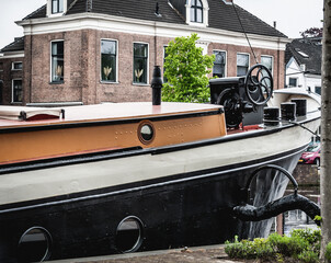 Fototapeta na wymiar Black-orange barge bow on the canal