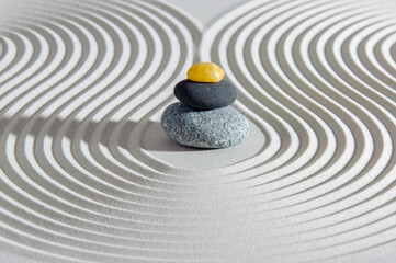 Fototapeta na wymiar Japanese zen garden with yin yang stone in textured sand