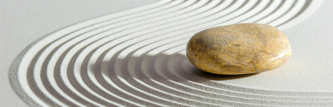 Japanese zen garden with yin yang stone in textured sand