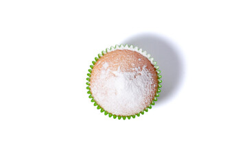 Vanilla cupcake sprinkled with powdered sugar. Homemade cupcake in paper liners isolated on white...