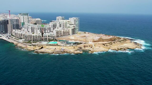 Aerial 4K footage of a drone flight over Slima (Sliema) district with fort Tigne in front of peninsula in Valetta, Malta.